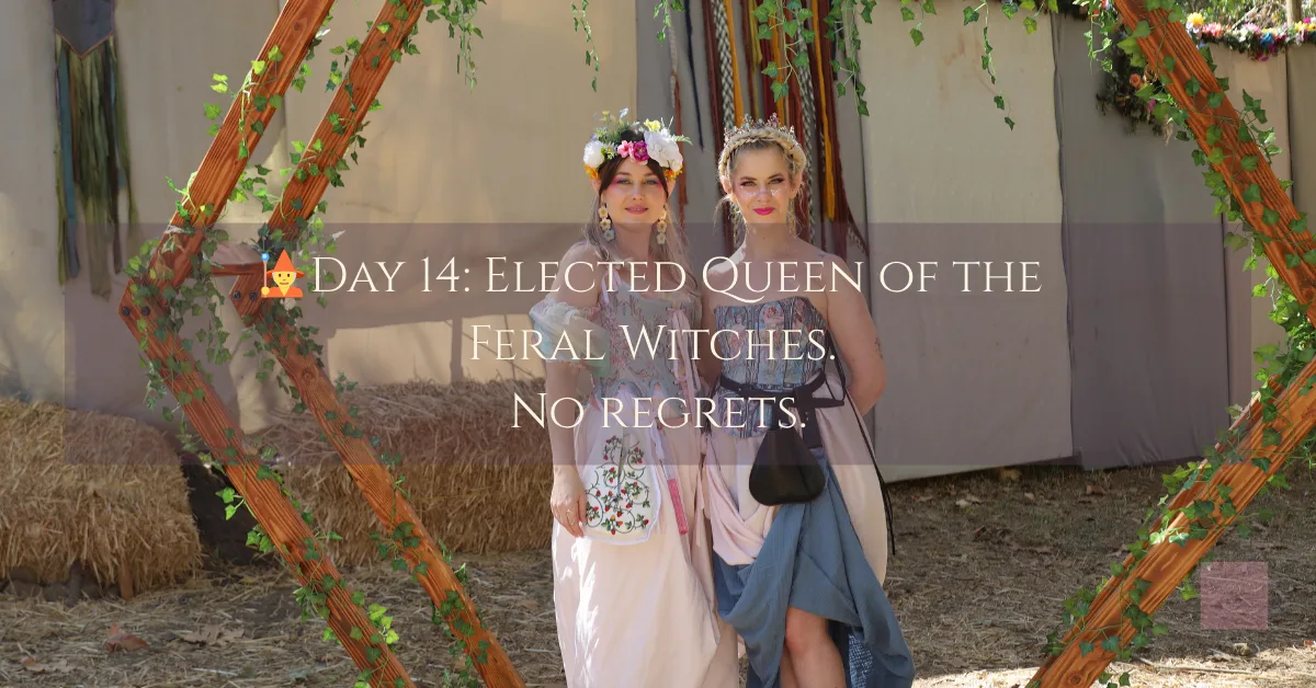 Two women in fantasy dresses stand confidently beneath a wooden arch at a renaissance fair. One wears a crown of flowers the other a silver tiara. Over the image the caption reads “🧙Day 14: Elected Queen of the Feral Witches. No regrets.”