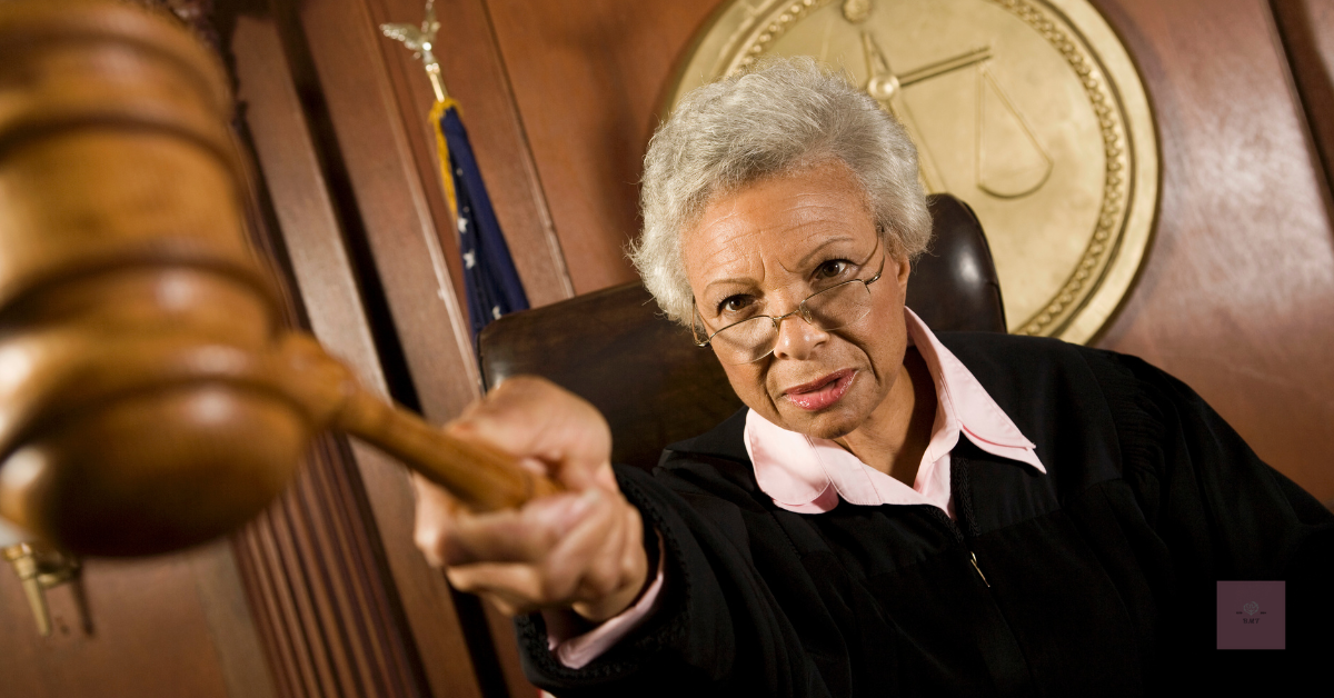 A stern female judge swinging a gavel toward the viewer with authority.
